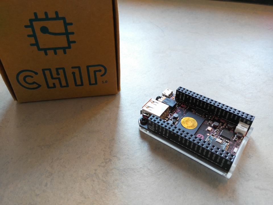 Image of the C.H.I.P computer and packaging on a textured surface